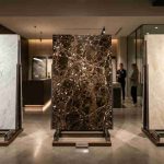 Три премиальных слэба мрамора из Италии, Турции и Ирана в шоуруме, демонстрирующие разнообразие текстур и оттенков на мировом рынке. p1