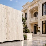 اسلب تراورتن کرم روشن در کنار ویلای لوکس با نمای سنگی کلاسیک و پنجره‌های تیره